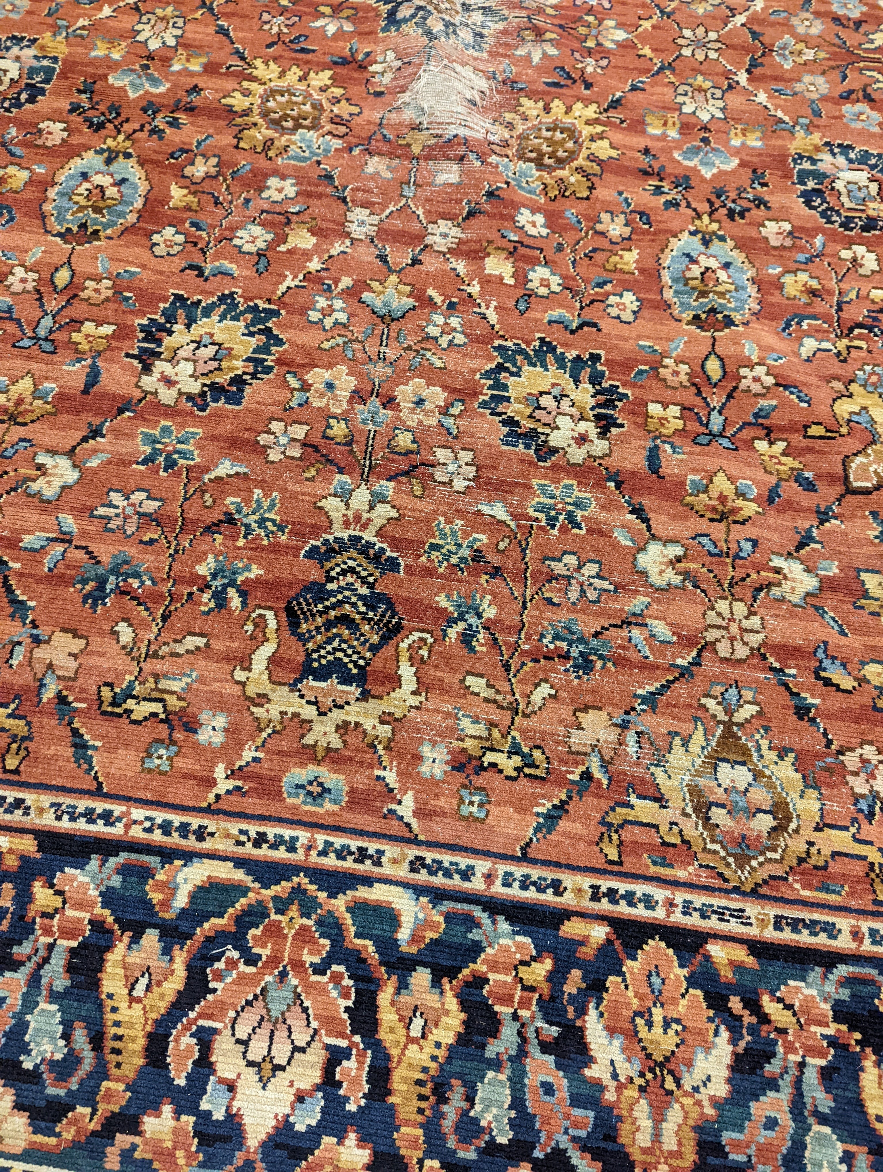 A Persian style machined brick red ground carpet (severely worn), 392 x 286cm